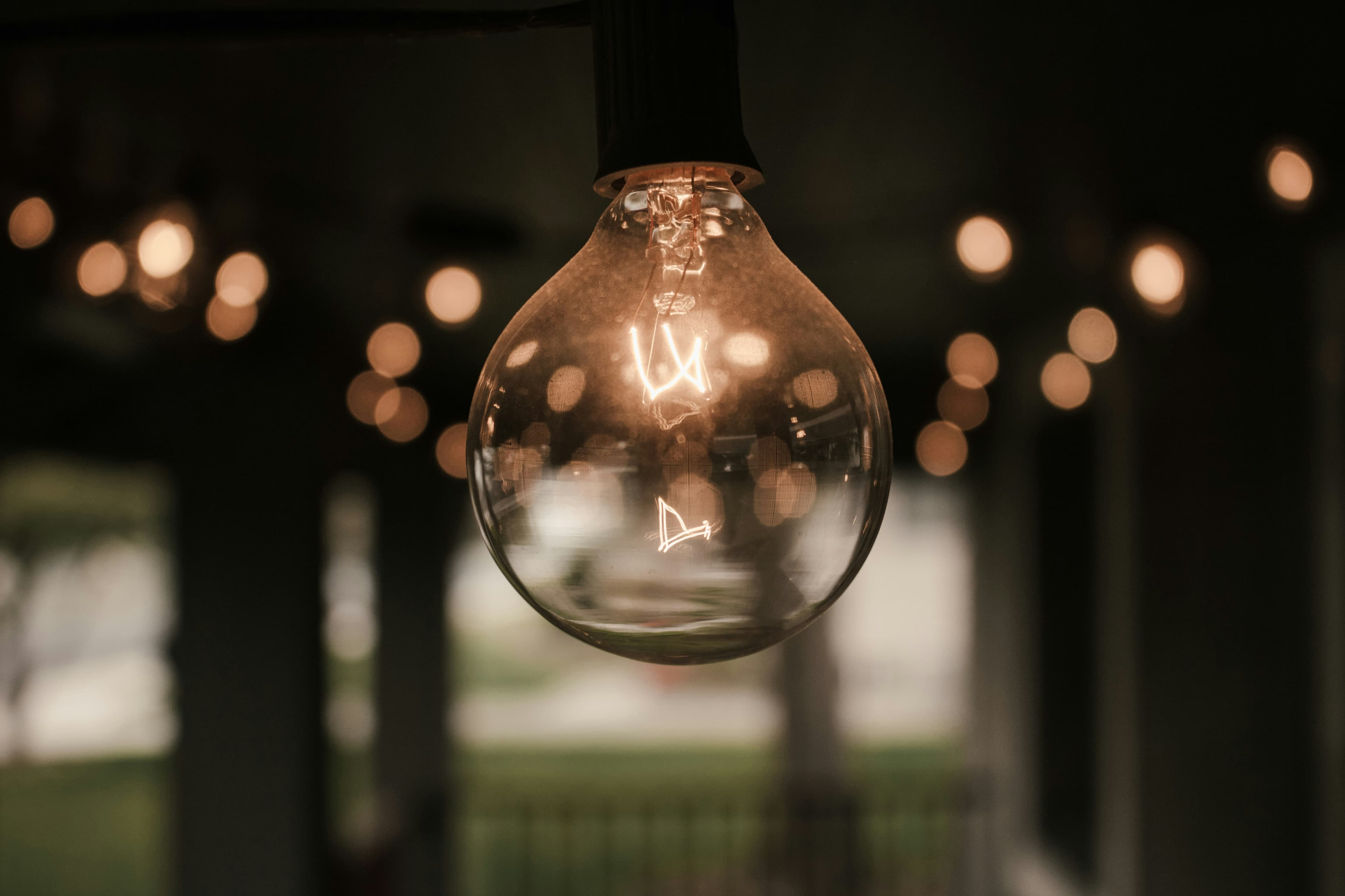 A lightbulb on blurry bokeh background of other lightbulbs in the back